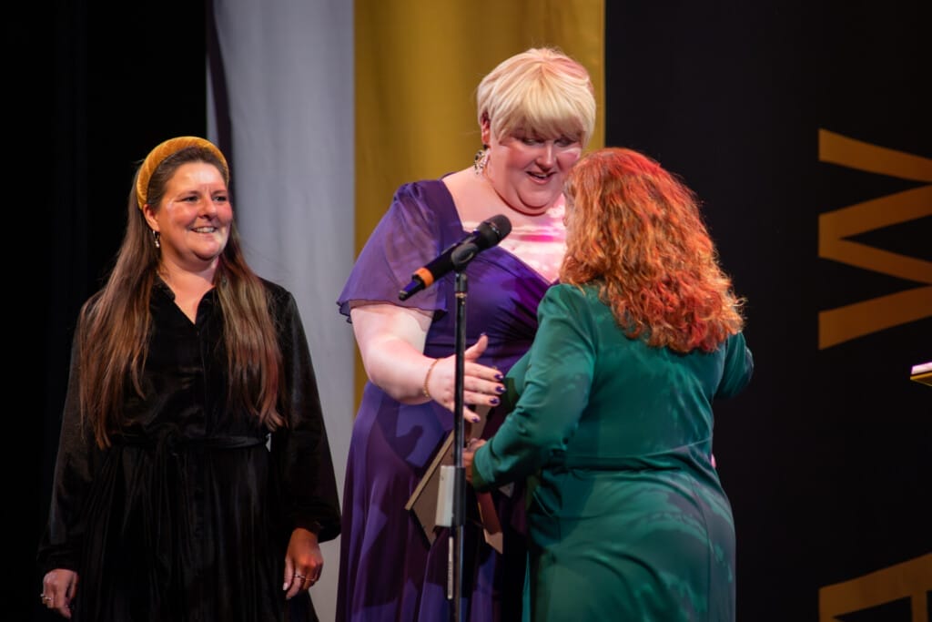 Interim COO Jo Philips and Head of People & Culture Scarlet Morgan accept the People First Award on stage at the Chamber Awards 2026.